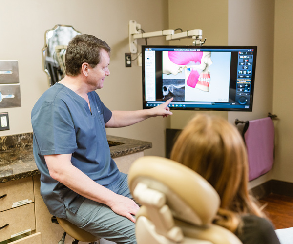 Dr. Baier reviewing digital dental images on a screen with a patient