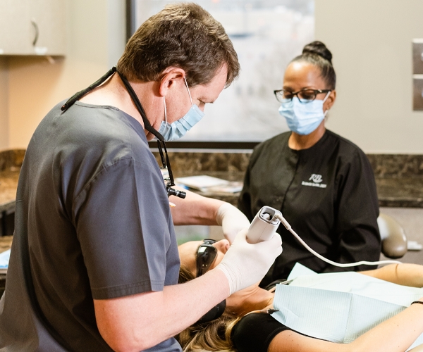 Dr. Baier and a dental assistant treating a patient