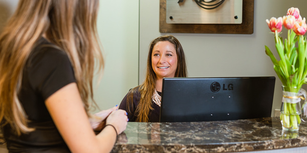 Patient checking in at the front desk of Dr. Rodney Baier's dental office