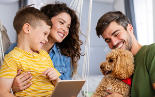 Family with a child and dog reading together, for preventive family dentistry